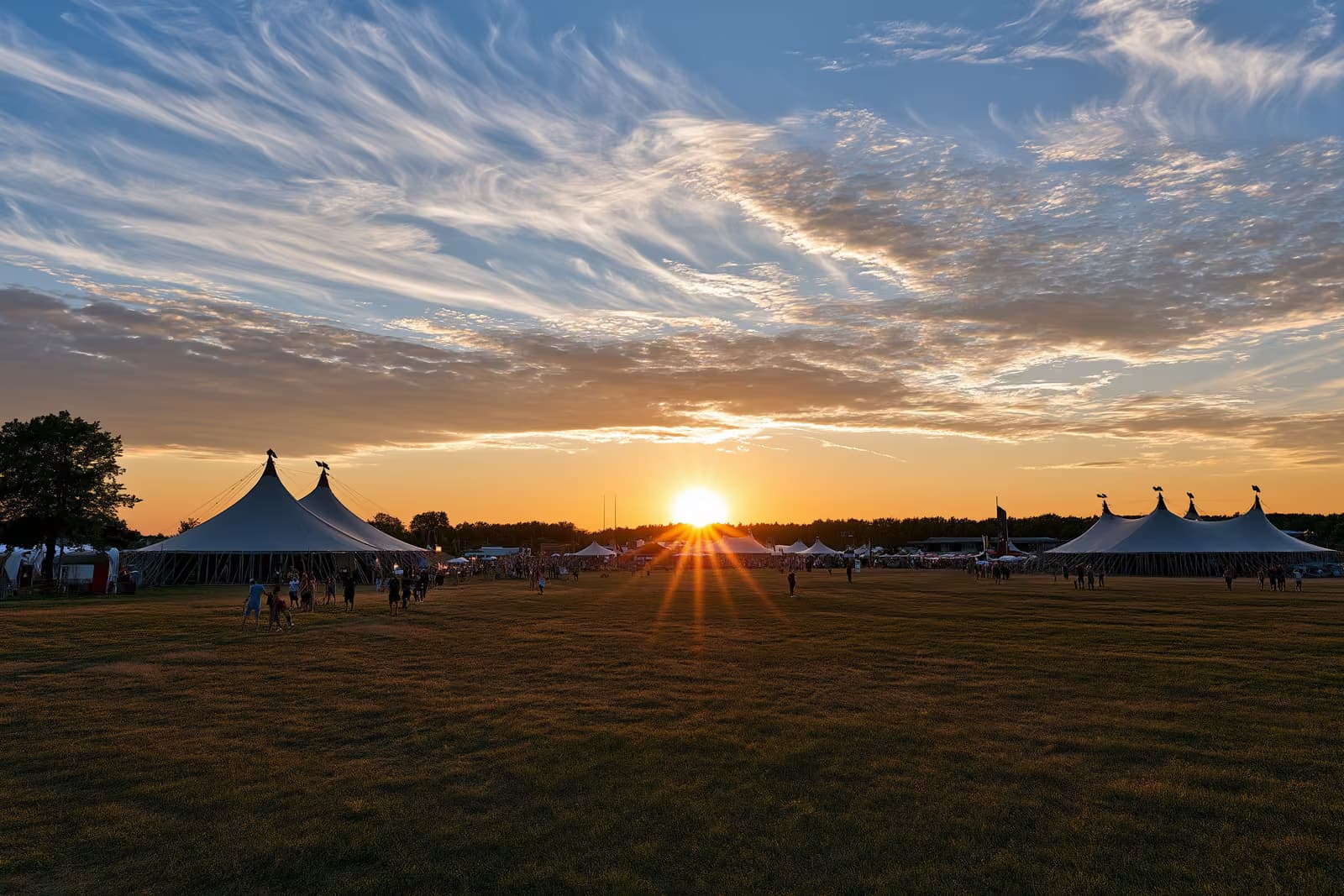 Grandes tendas de circo montadas em um campo aberto sob o céu de uma noite de verão em Berlim.