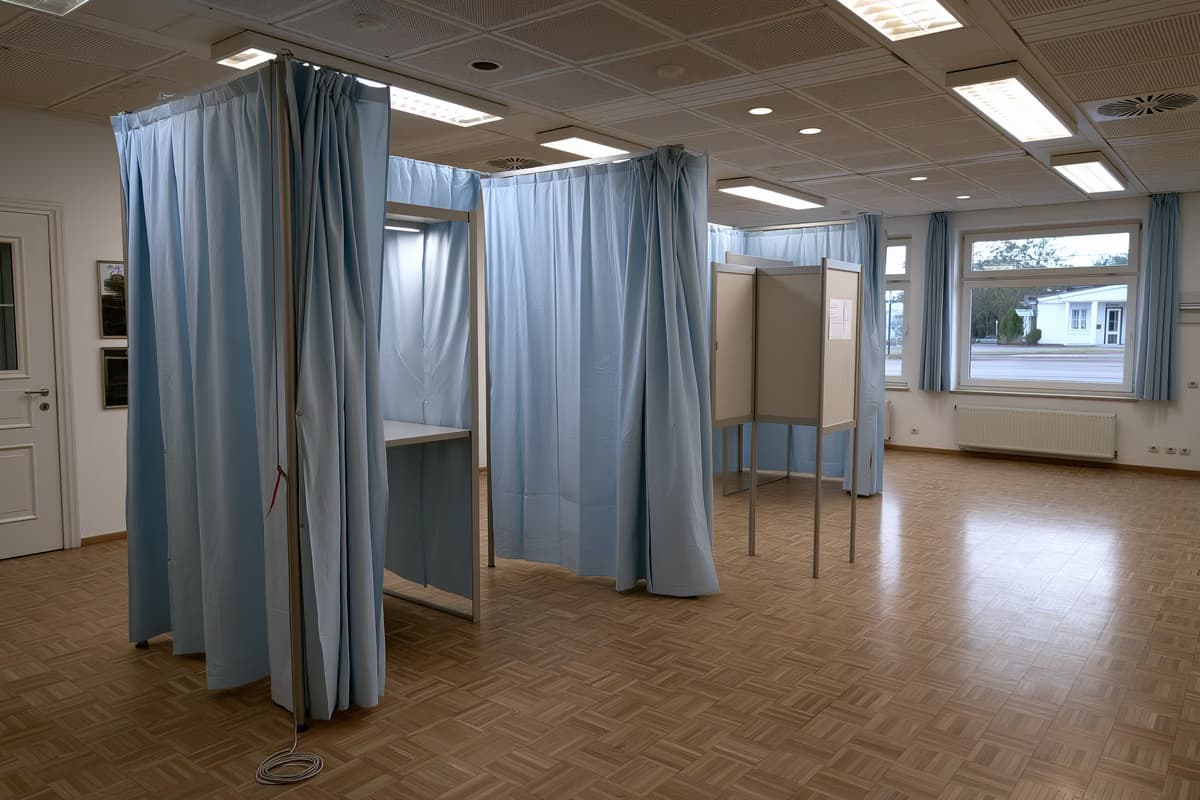 Uma cabine de votação vazia com um lápis preso a um barbante em um centro comunitário alemão.