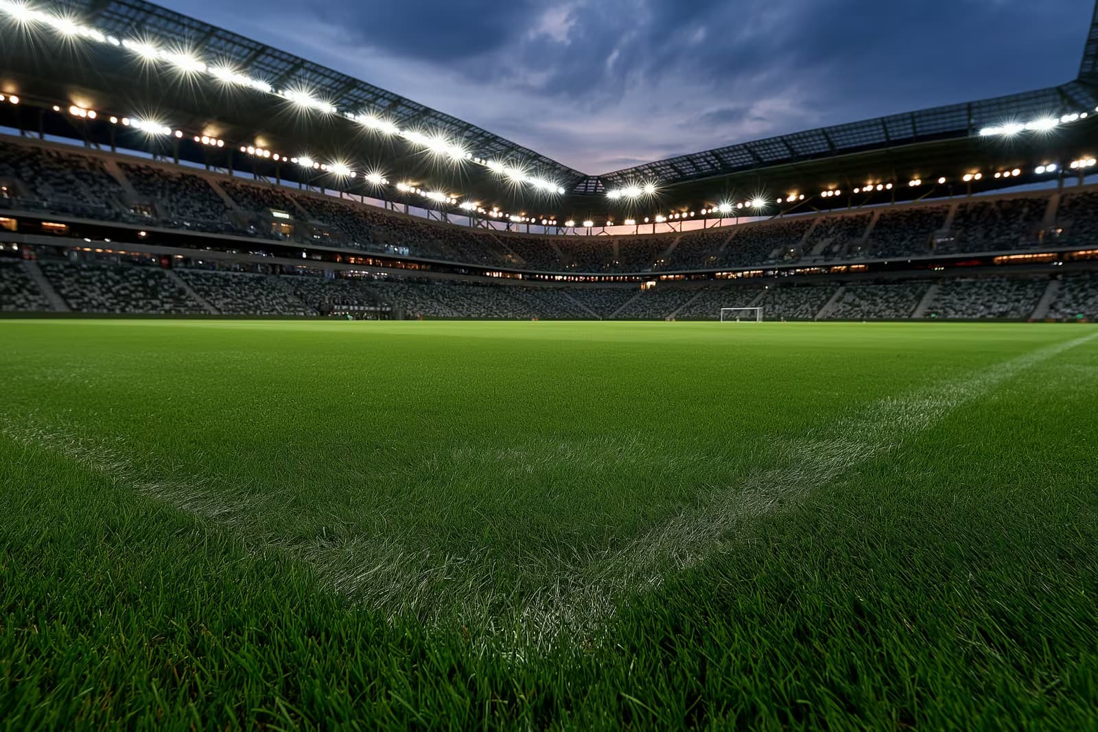 Um estádio de futebol iluminado ao entardecer, antes de uma partida noturna.