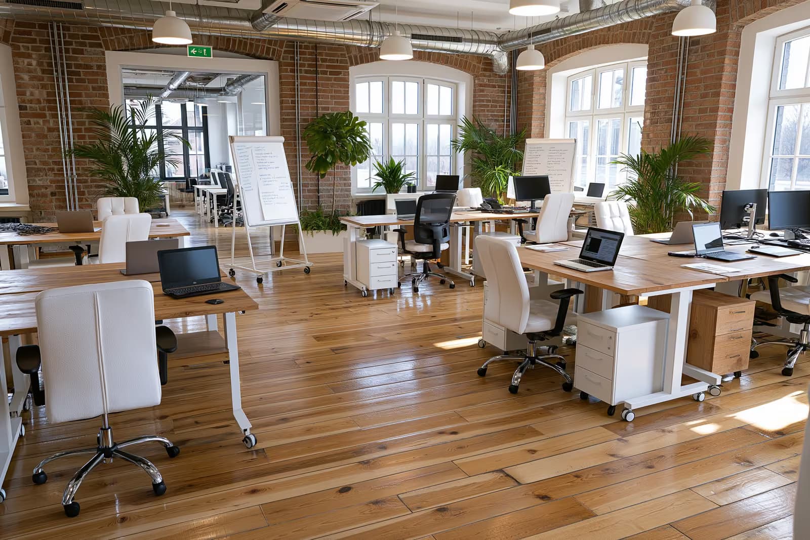 Fundadores trabalhando juntos em mesas em um escritório moderno de uma startup alemã.